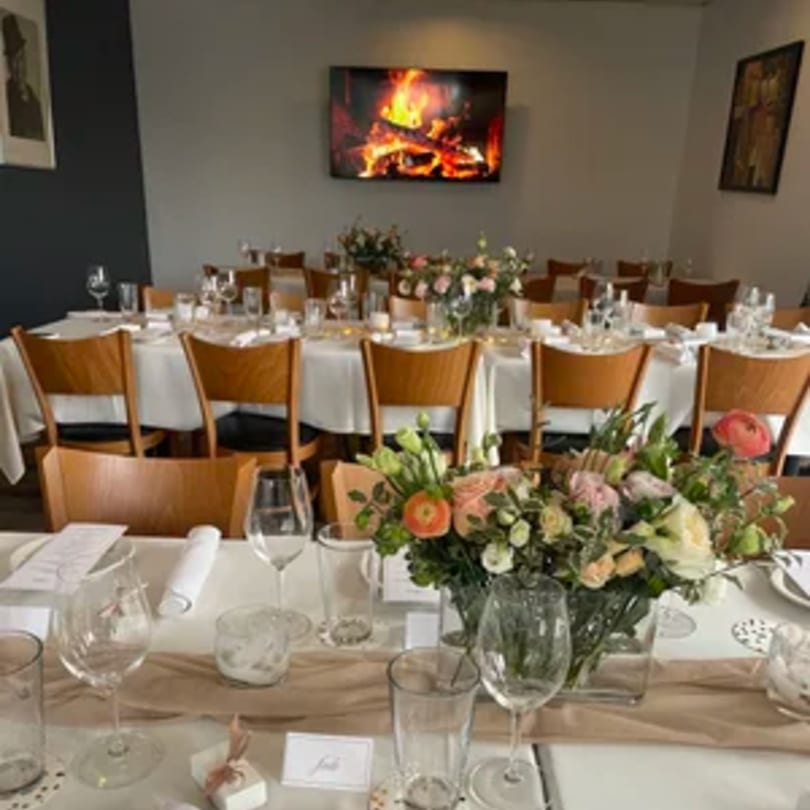 Elegantly set tables with floral centerpieces and a fireplace screen in Tommy V's Urban Kitchen & Bar.